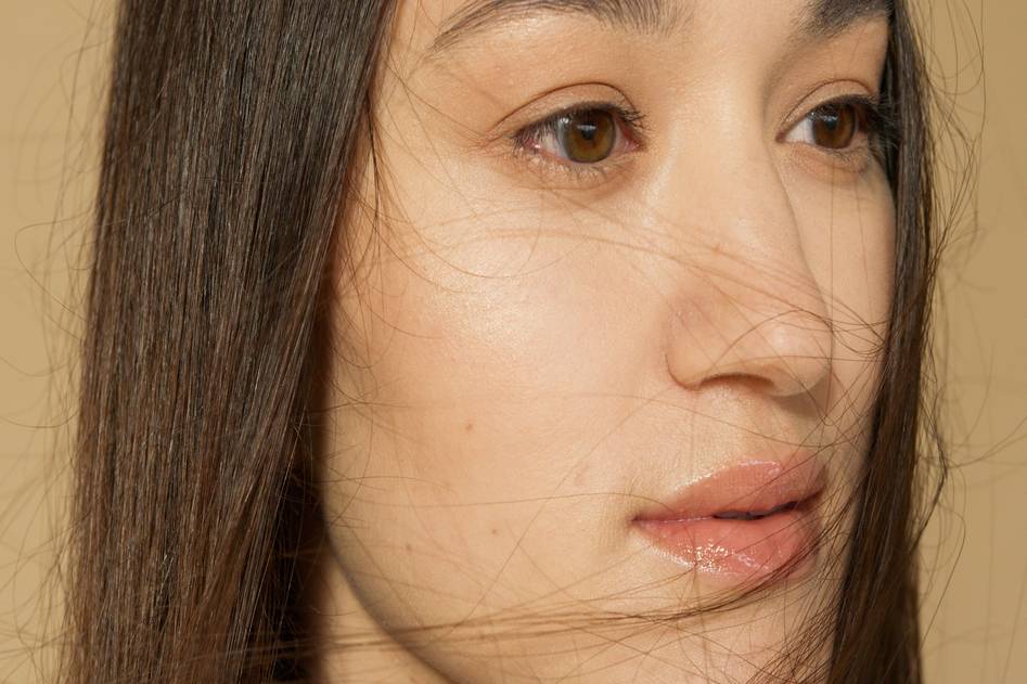 Clean non-toxic makeup products arranged on neutral linen with soft natural lighting